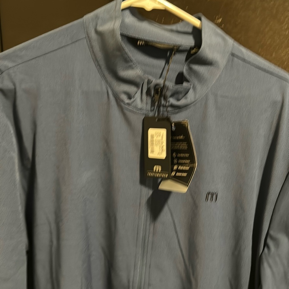 Travis Mathew grey sweater with Tito’s logo